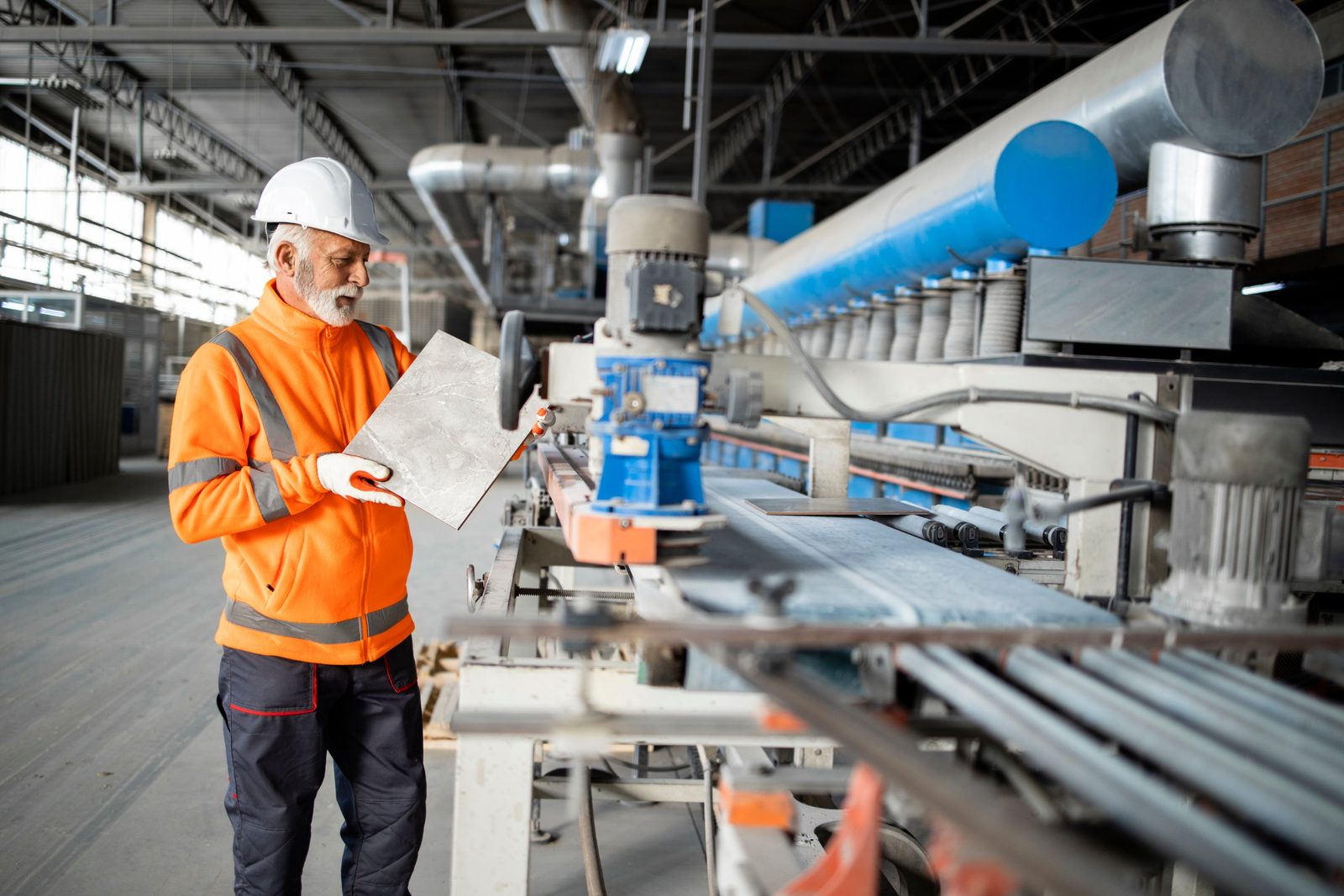 Inspector checking a finished tile on a production line
